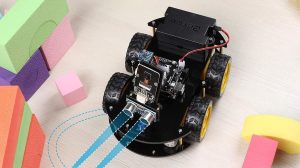 A black and yellow robot with wheels and wires